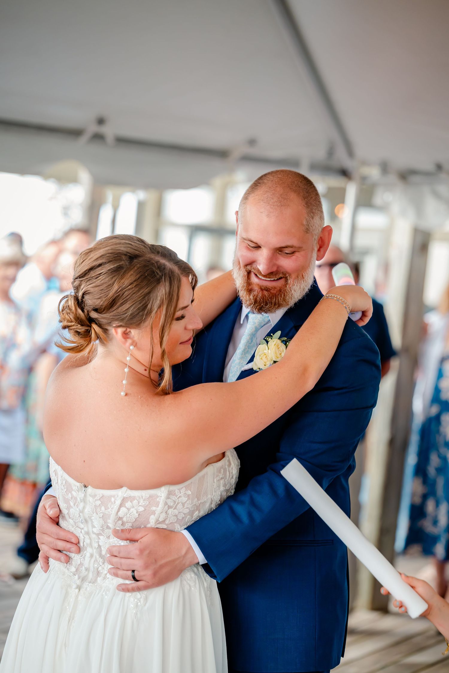 Wedding couple shares joyful dance moments under a white tent during their reception celebration.