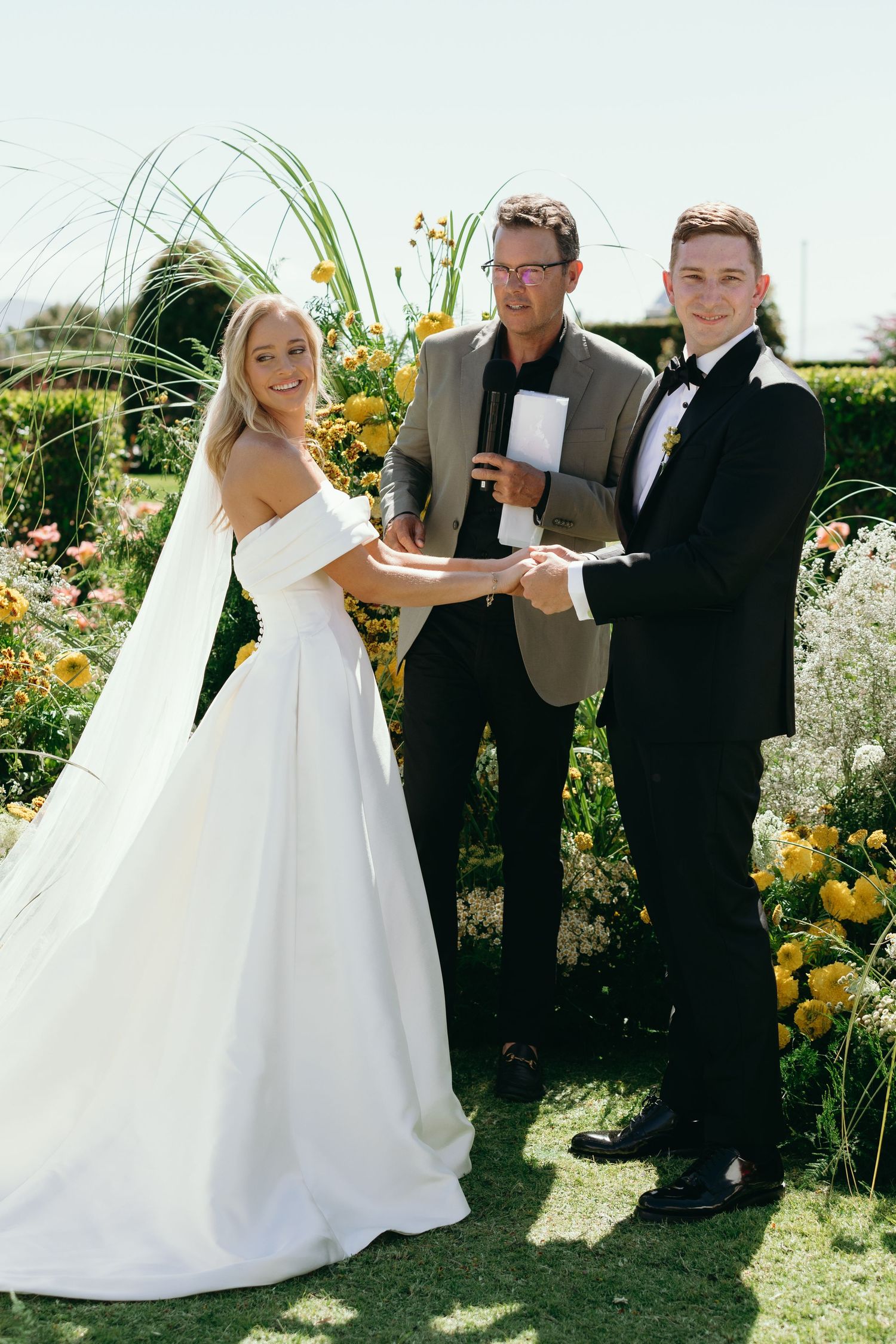 A sequence of wedding ceremony photos showing a bride and officiant outdoors in a garden with yellow flowers.