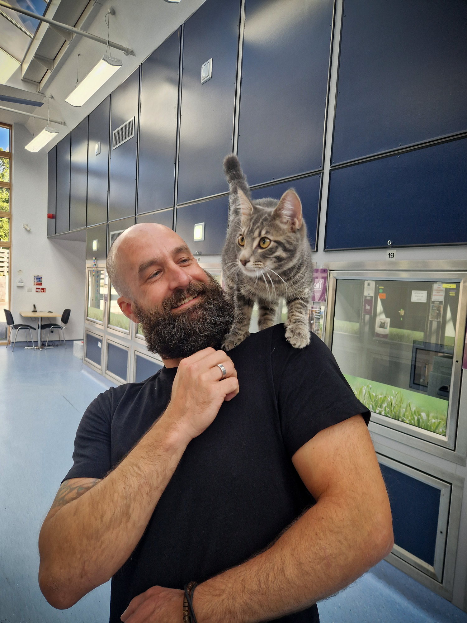 Russ Stedman pet photographer standing in Cats Protection with a grey kitten on his shoulder