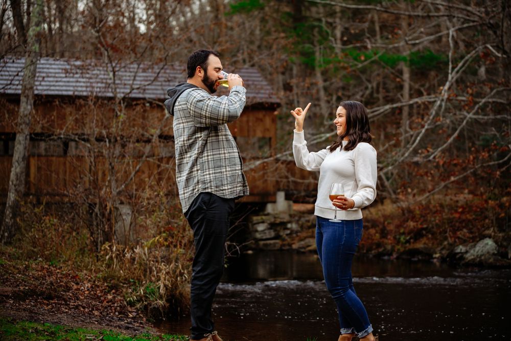 A couple shares a romantic moment together in a wooded area during an autumn engagement photoshoot.