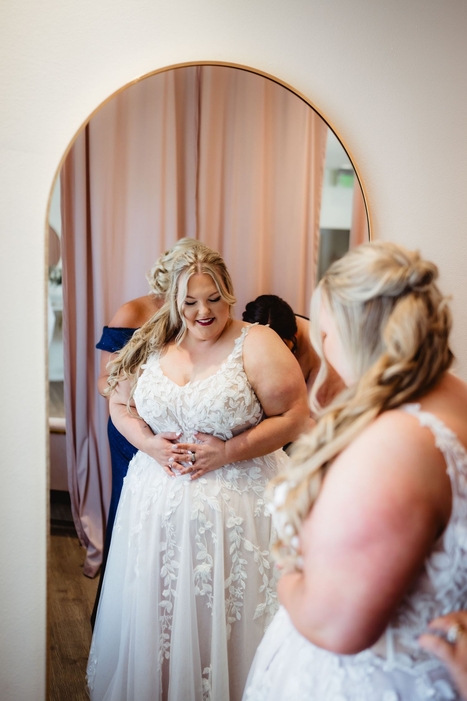 A sequence of photos showing someone getting dressed in an elegant white lace wedding gown with delicate details.