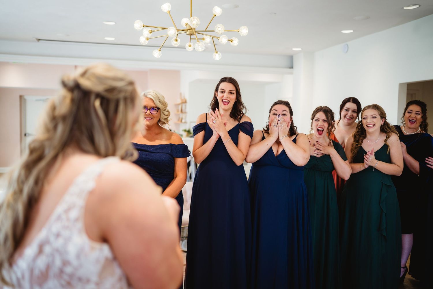 Wedding party members in navy blue dresses and formal attire celebrate during a reception event.