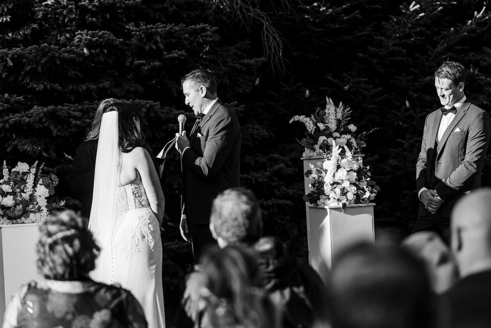 A series of candid black and white wedding photos showing emotional moments during an outdoor ceremony.