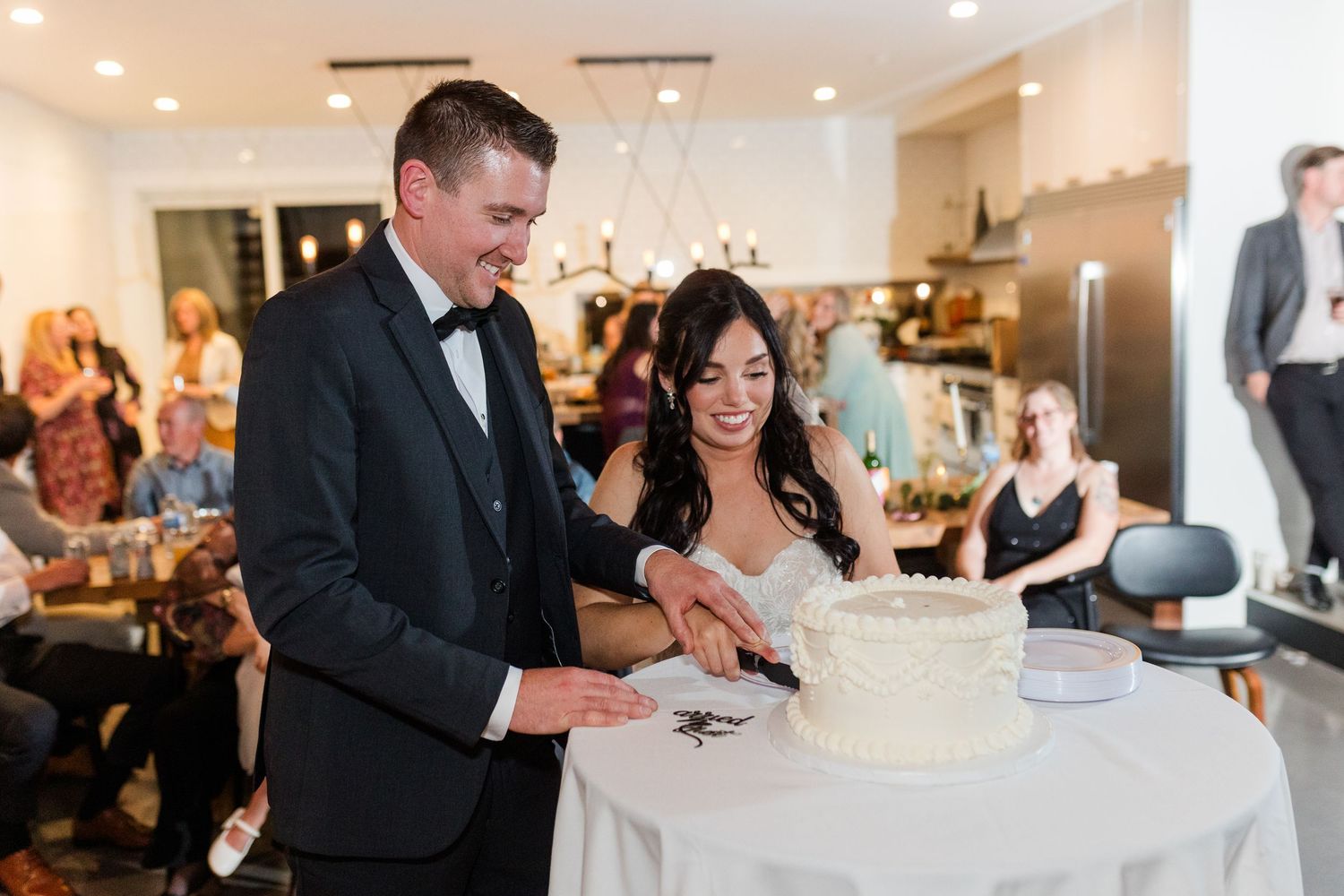 Wedding couple and guests enjoy a joyful reception celebration in an elegant indoor venue.