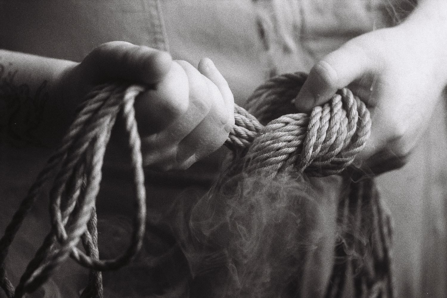 A person holds a hank of rope between their hands.