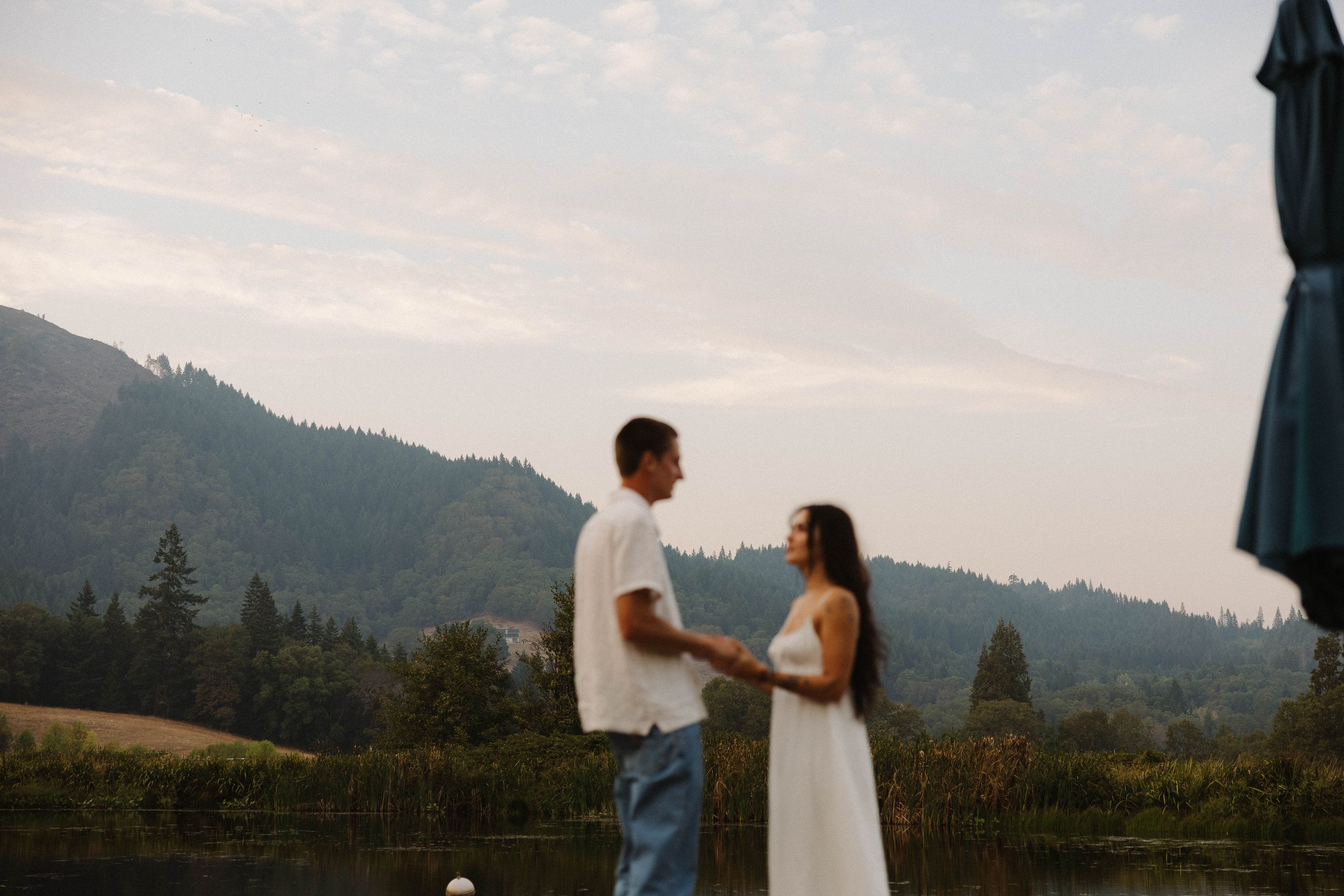 Couple walks along mountain path during sunset engagement photoshoot.