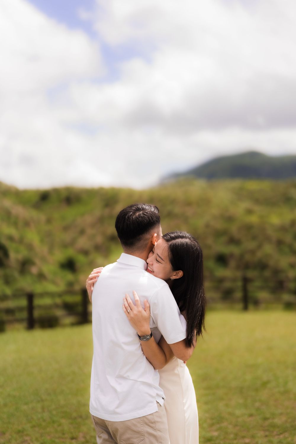 A romantic embrace captured between a couple  in a lush green hillside setting in Taiwan's Yangminshan National Park.