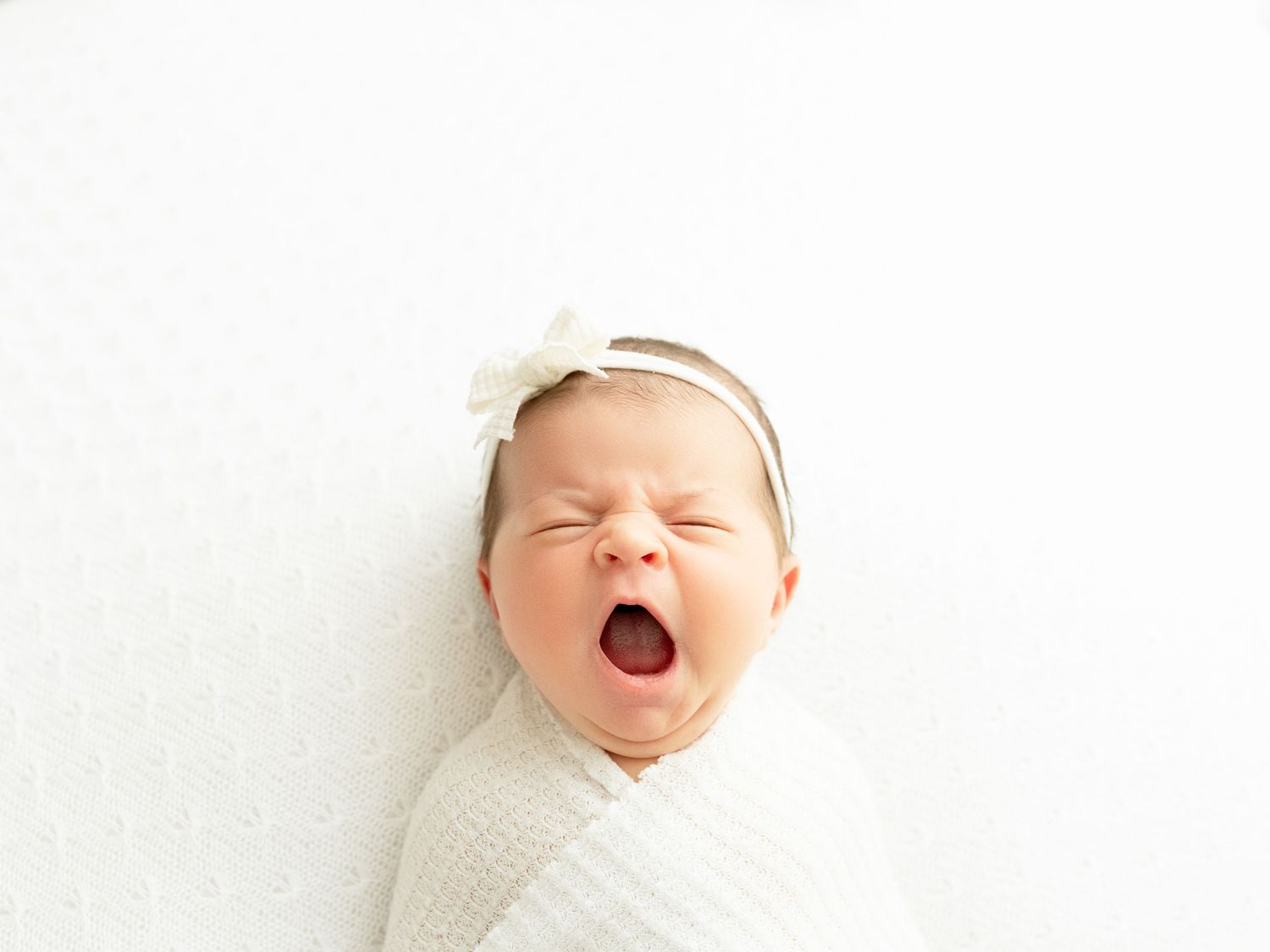 A series of four close-up photos showing a baby's happy expressions while wearing a white headband.