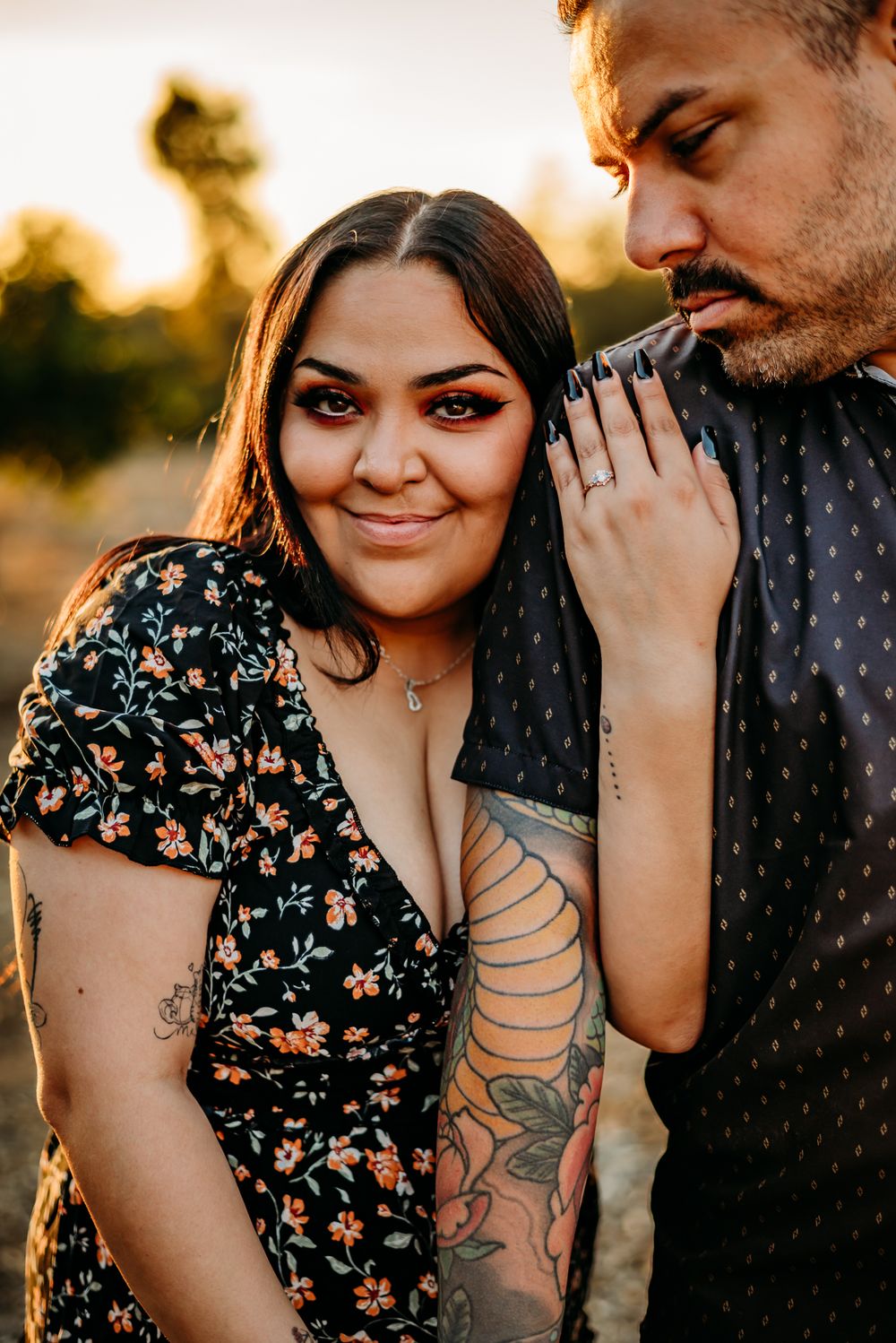 Intimate sunset portraits of couple with visible tattoos in warm evening light.