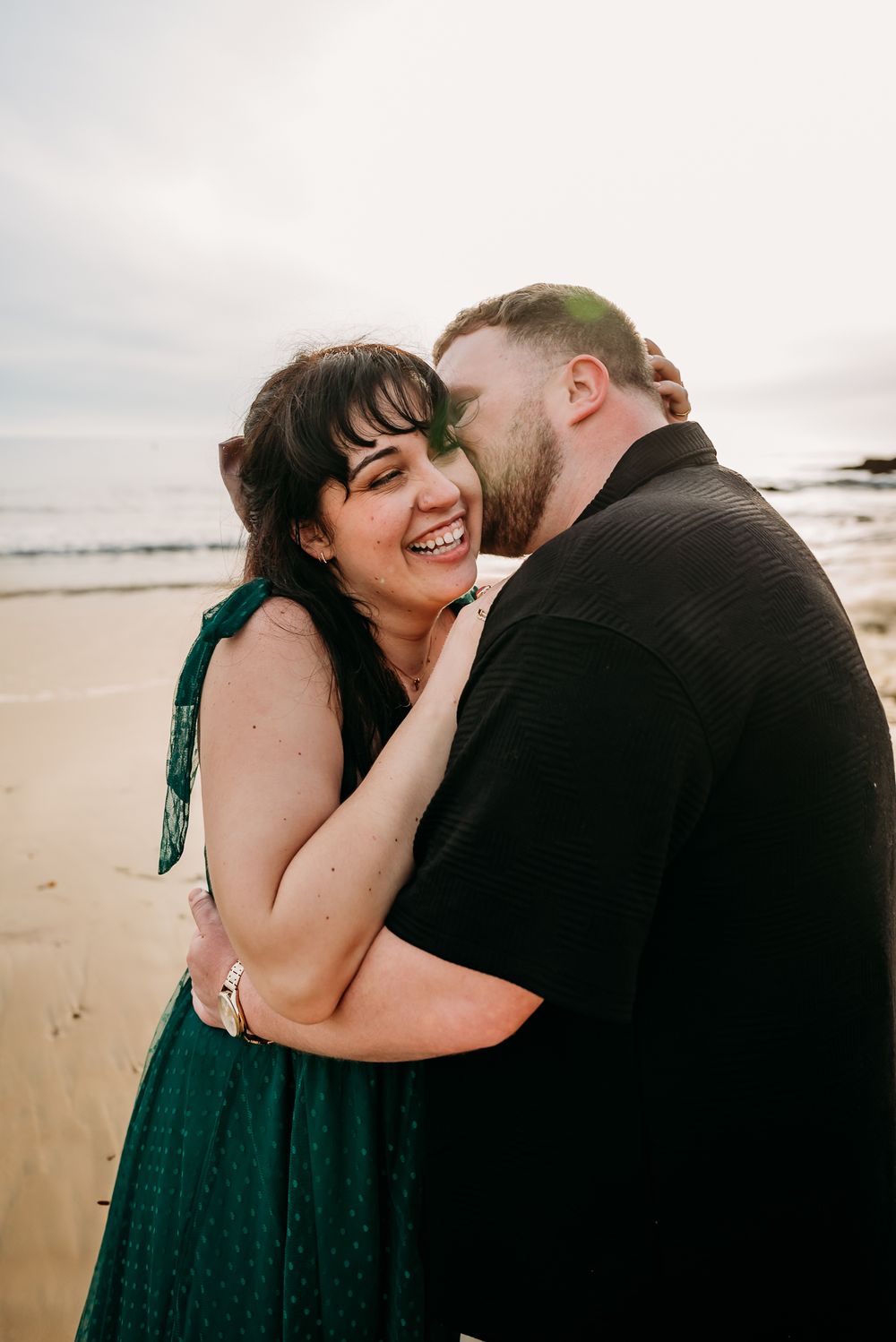Intimate beach photoshoot captures romantic moments between couple on sandy shore.