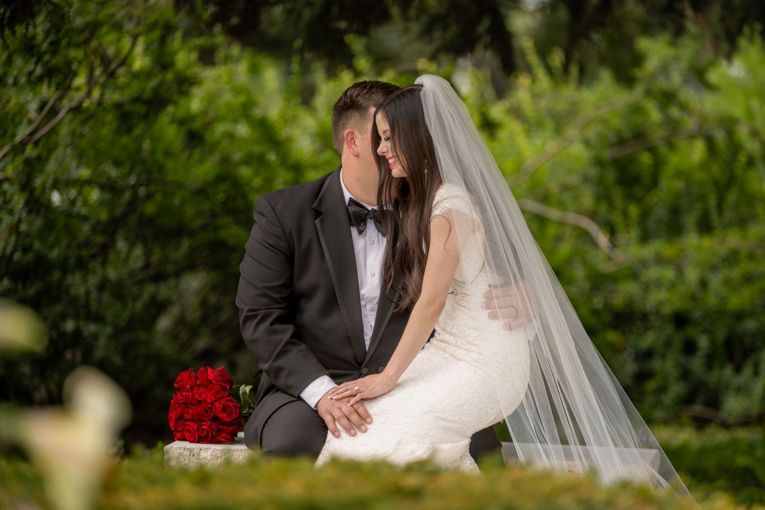 Bride and groom enjoying a private moment under a tree near their venue.