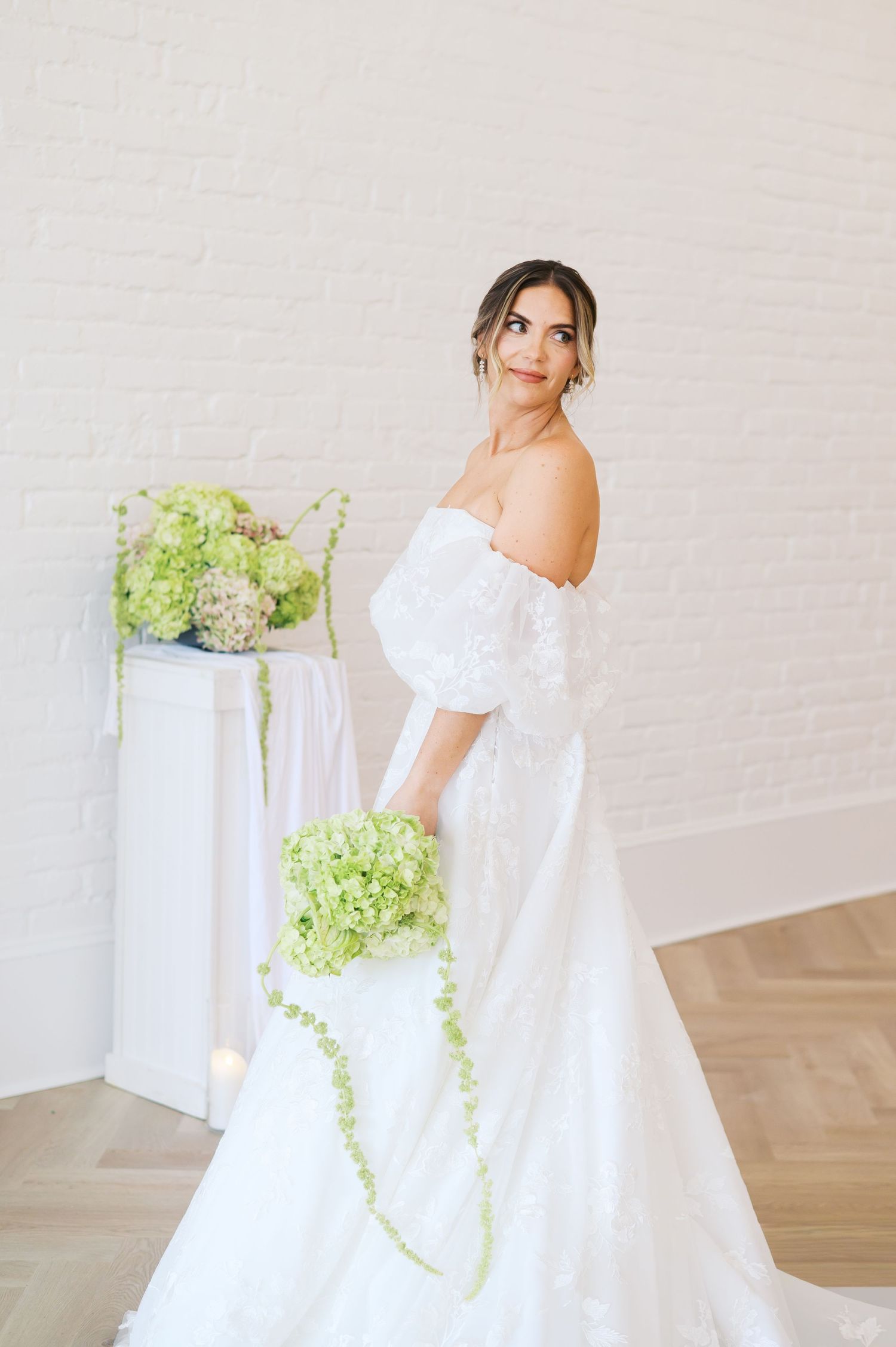 A romantic bridal portrait series showing an ethereal white dress and delicate floral arrangements against a light backdrop.