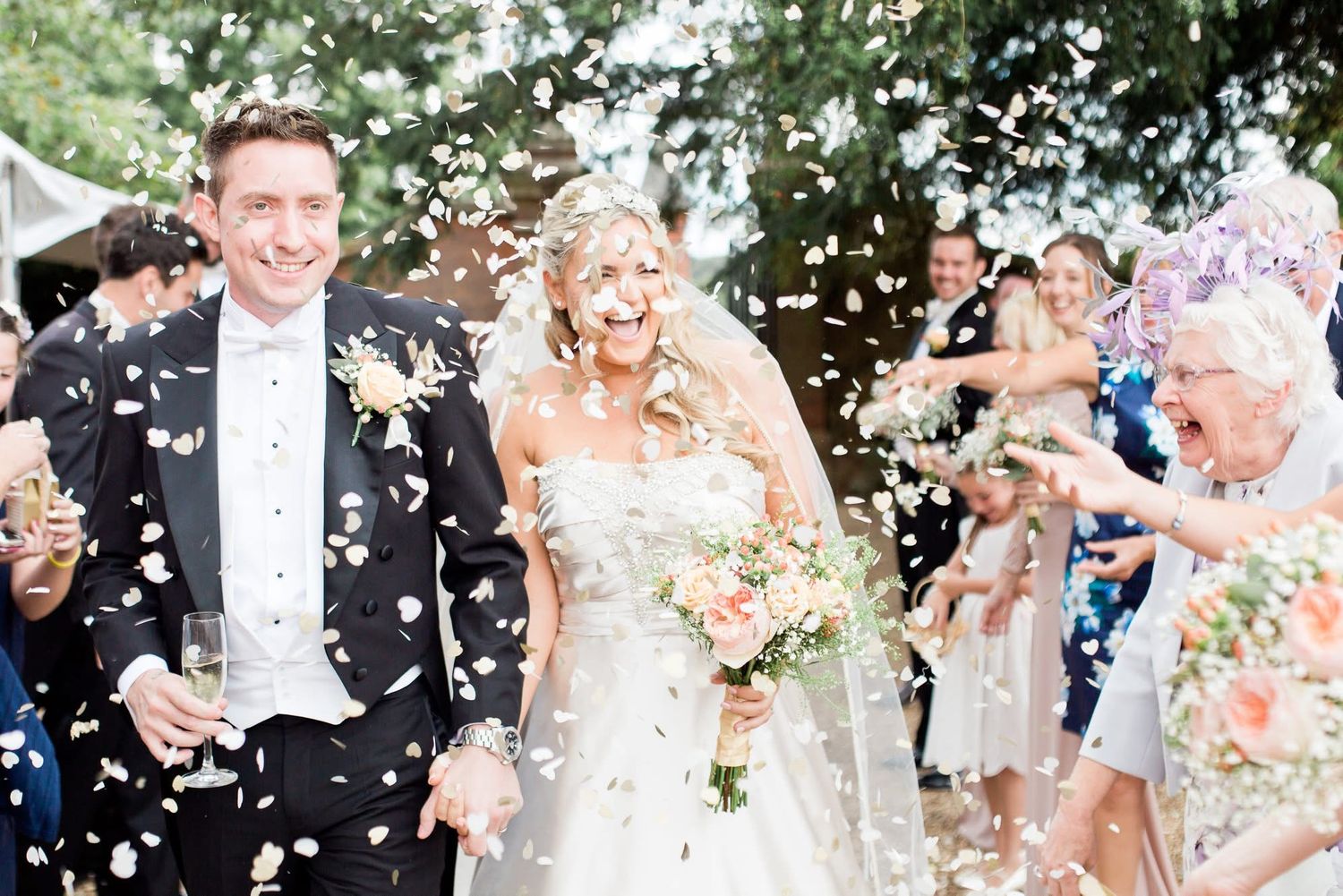 Festive outdoor wedding scene with confetti and celebration.
