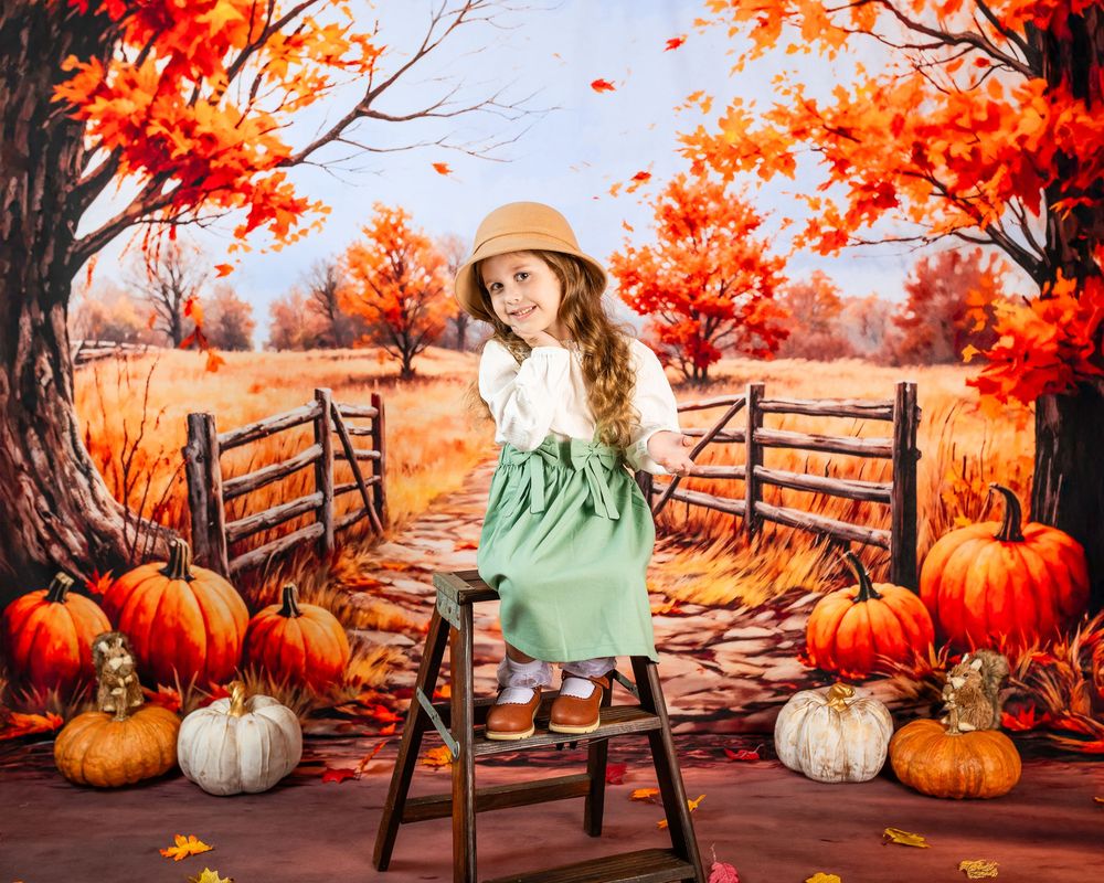 Autumn scene with orange pumpkins and wooden bench against vibrant fall foliage and rustic fence backdrop.