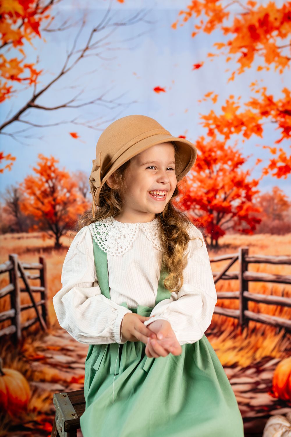 Charming fall portrait with vintage dress, straw hat, and bright orange foliage in the background.