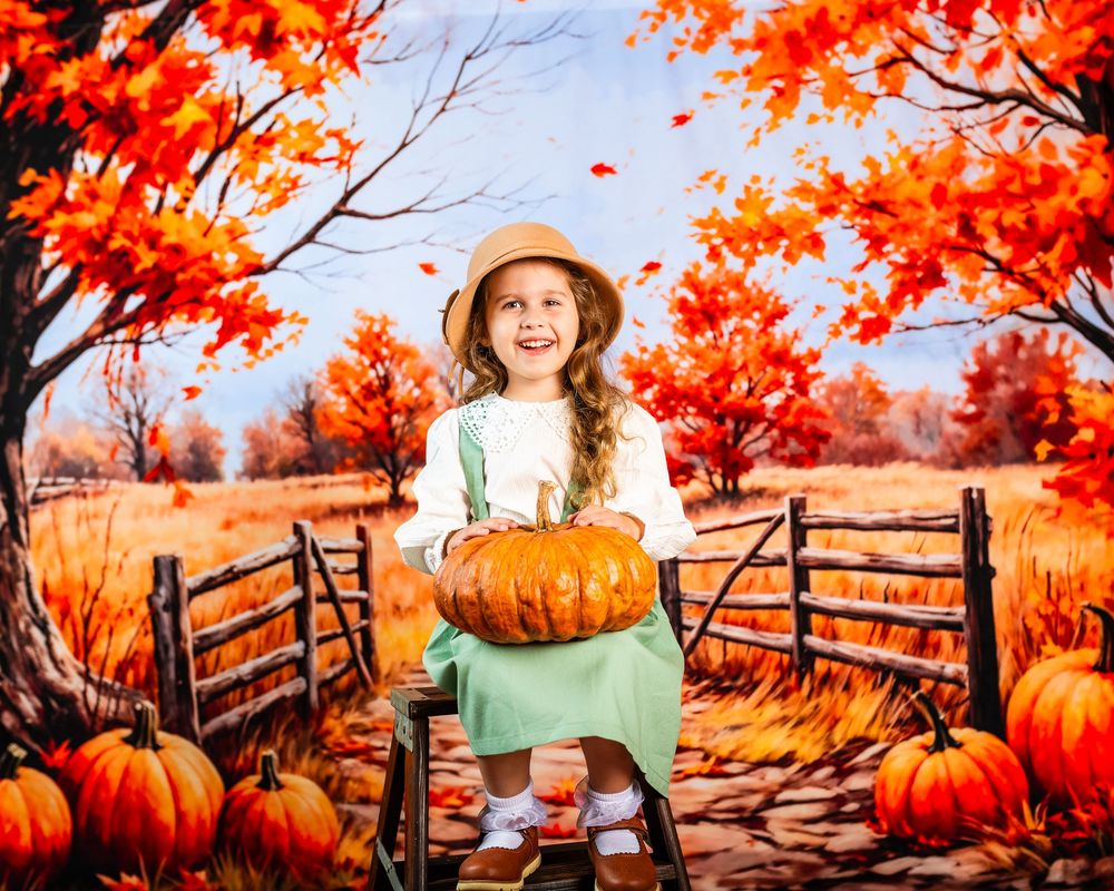 Autumn scene with orange pumpkins and wooden bench against vibrant fall foliage and rustic fence backdrop.