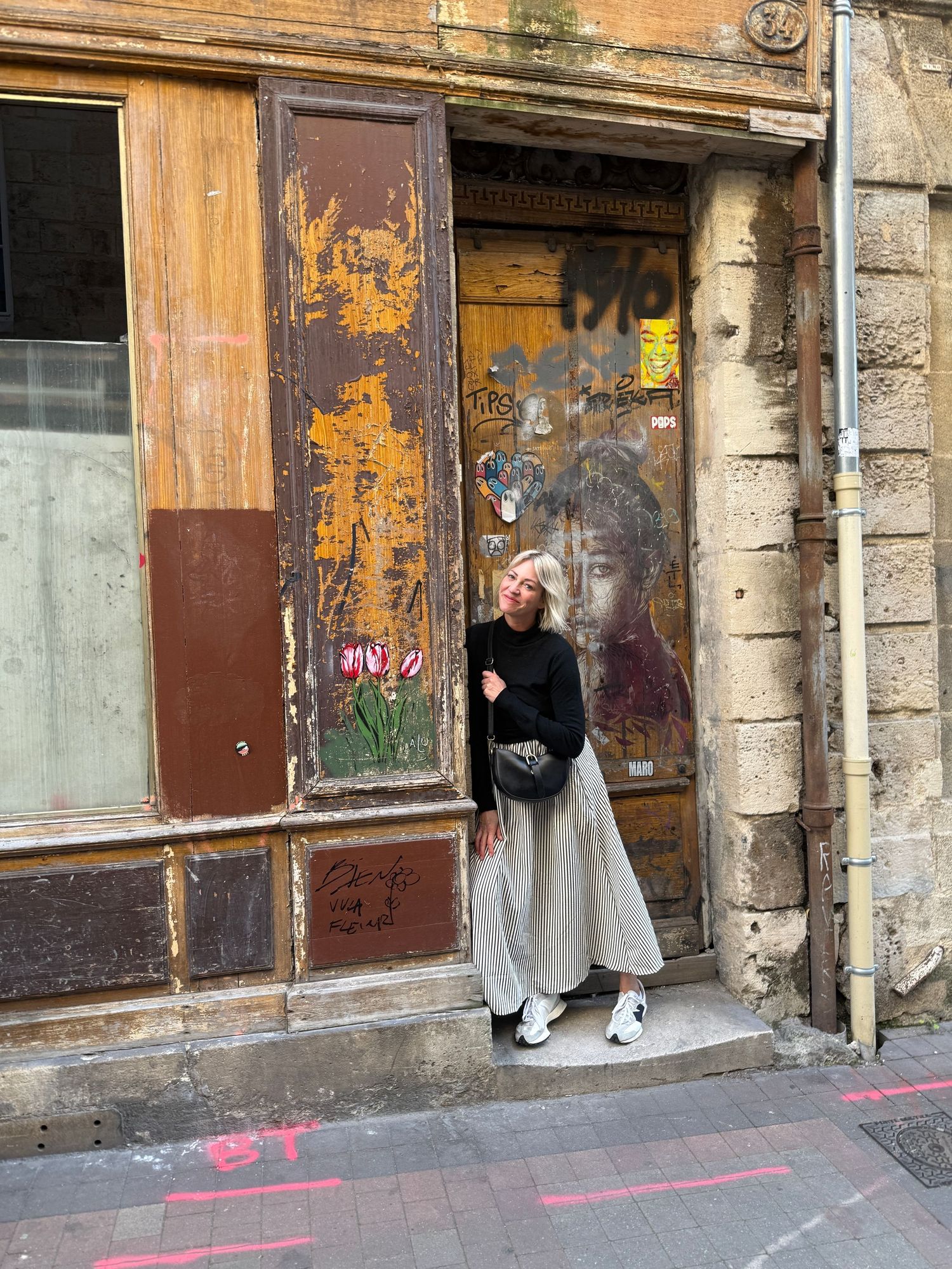 Weathered old building facade with peeling paint and rustic wooden doors.