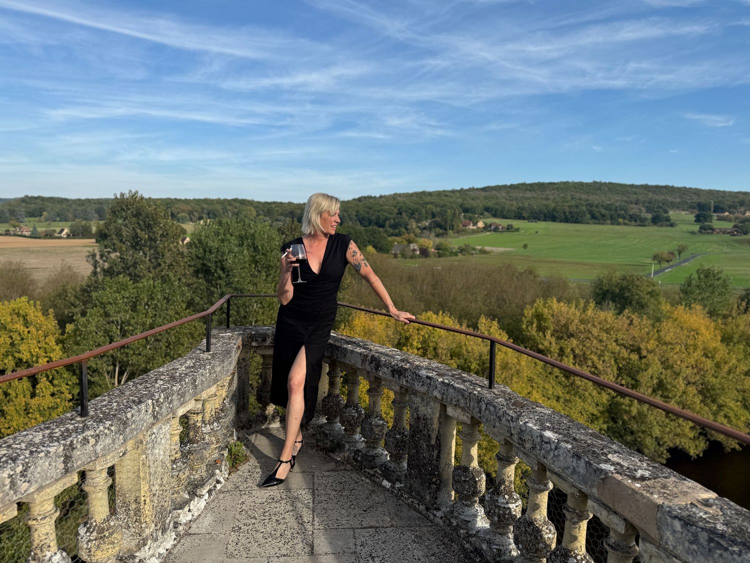 Stone balustrade walkway overlooking scenic countryside and rolling hills.