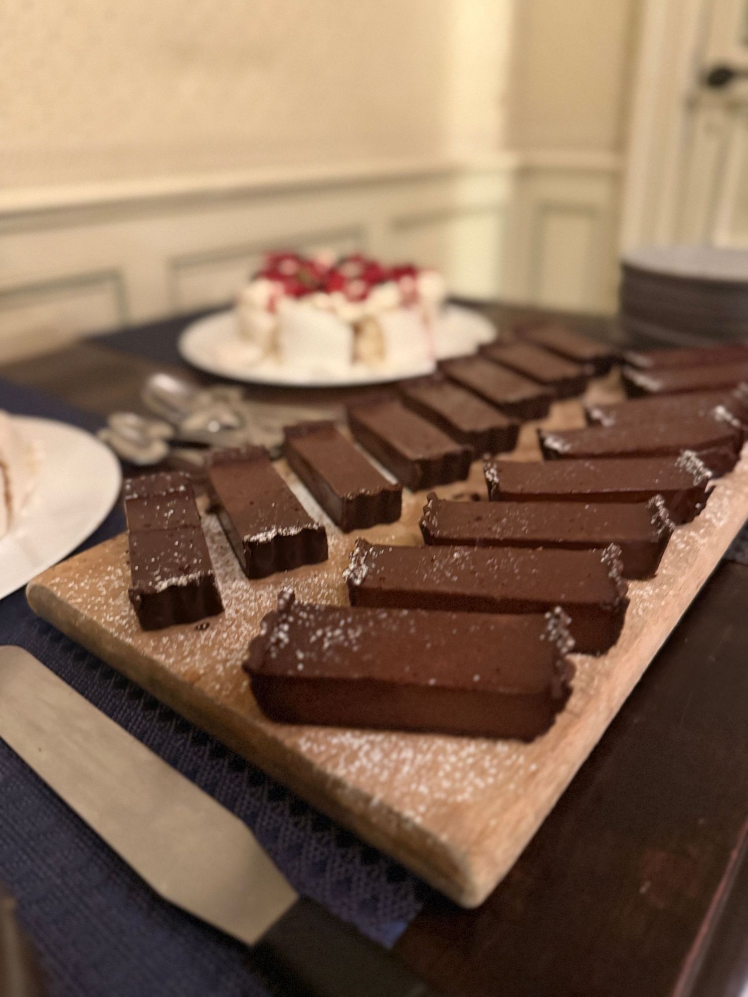 Rows of homemade chocolate bars sprinkled with sea salt on a dark surface.