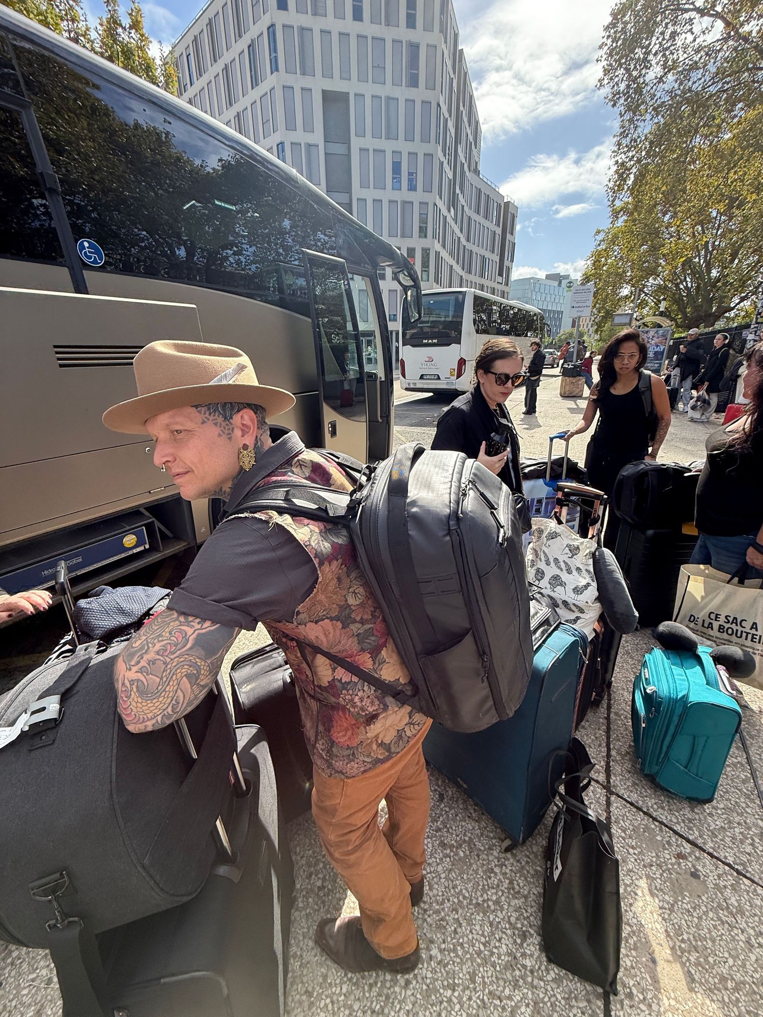 Loading luggage and equipment into a tour bus on a sunny day.