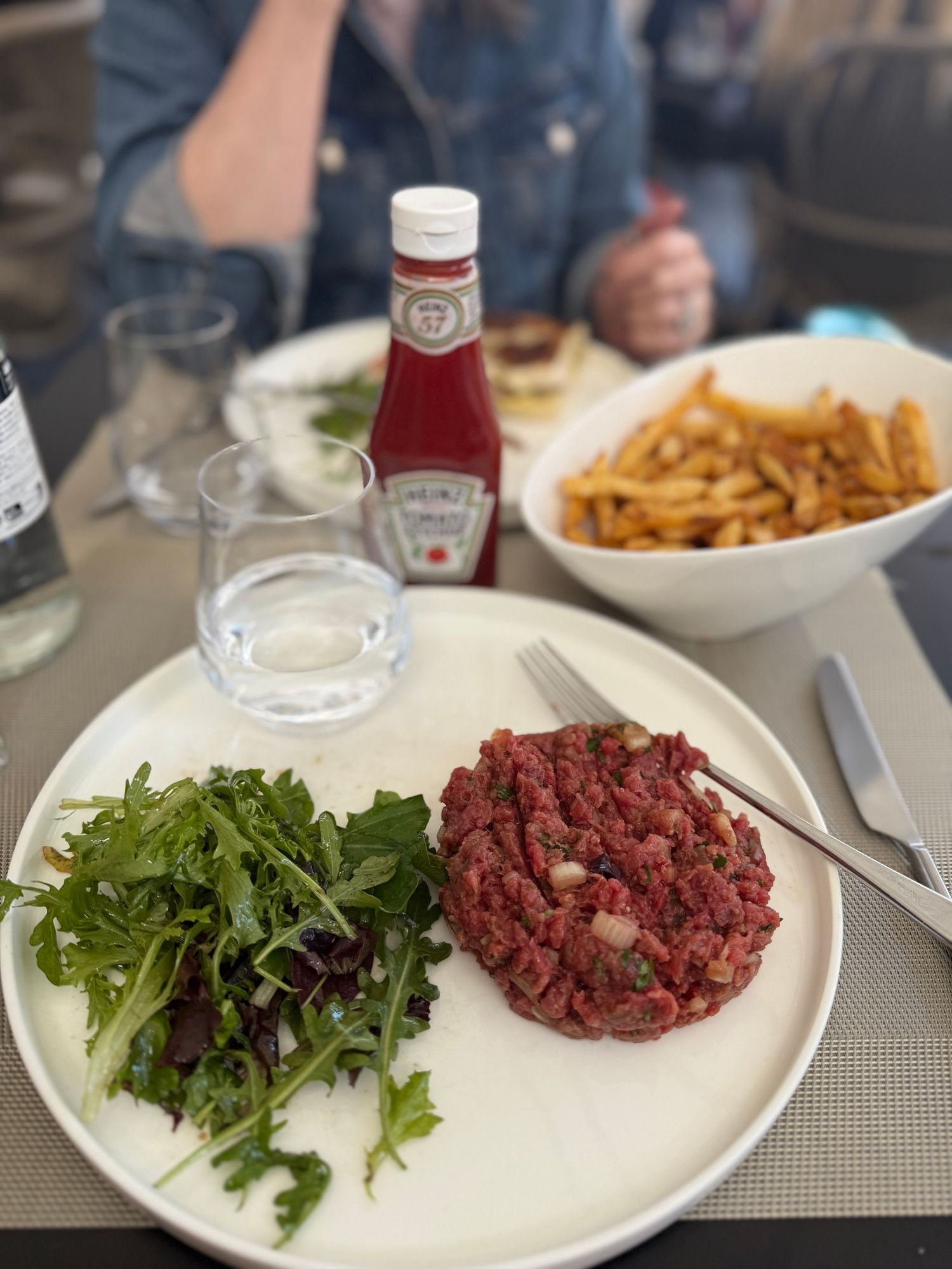 A plate of steak tartare served with fresh green salad and garnish at an upscale restaurant.