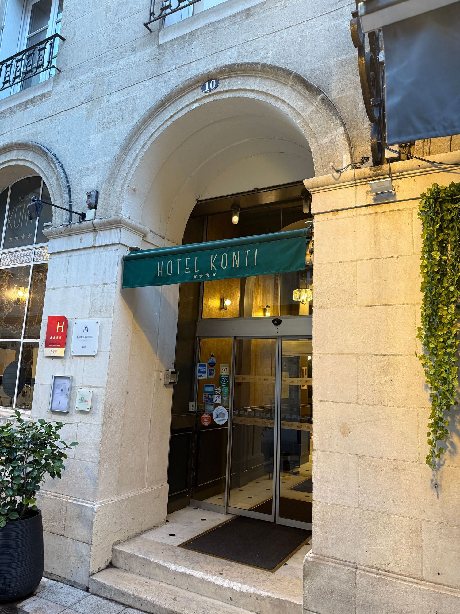 Entrance to Hotel Zunft with stone archways and green plants decorating the facade.