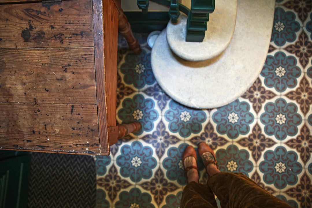 Close-up details of vintage wooden furniture and decorative patterned tiles.
