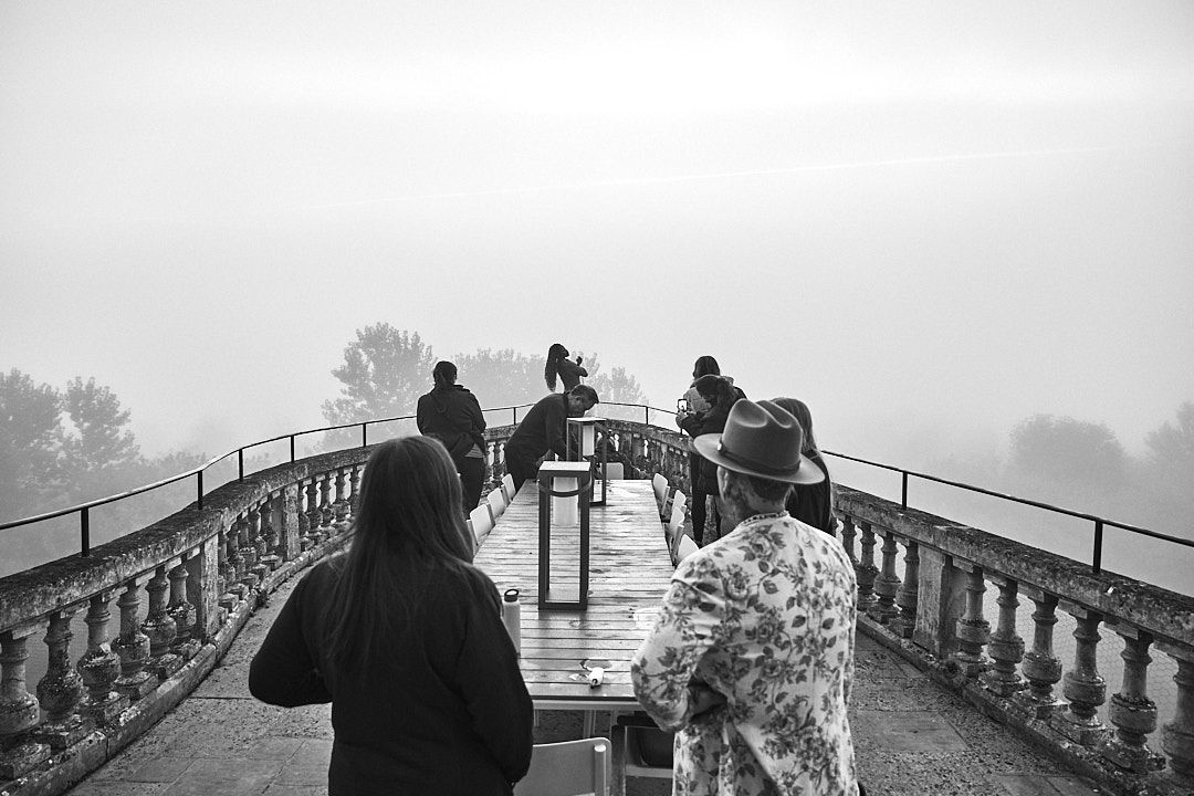 Misty panoramic view of people enjoying a scenic overlook at a historic site.