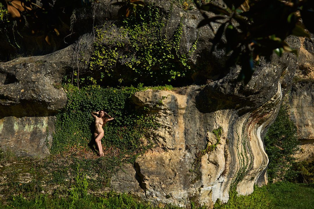 Rock climbing routes on natural limestone cliffs surrounded by vegetation.