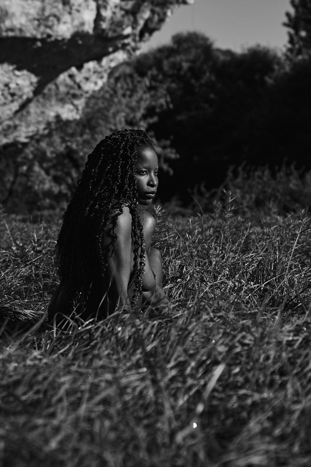 Black and white portrait in tall grass with natural lighting.