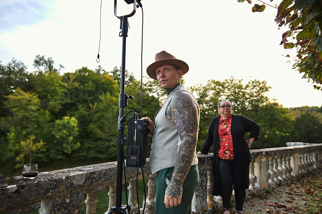 Photography equipment and lighting setup visible along stone balustrade during outdoor photo shoot.