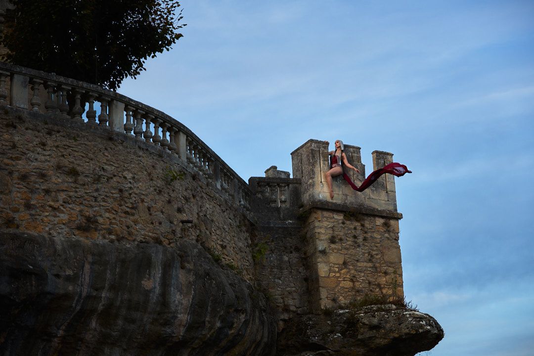 Historic stone fortress walls and battlements silhouetted against a dusky blue sky.