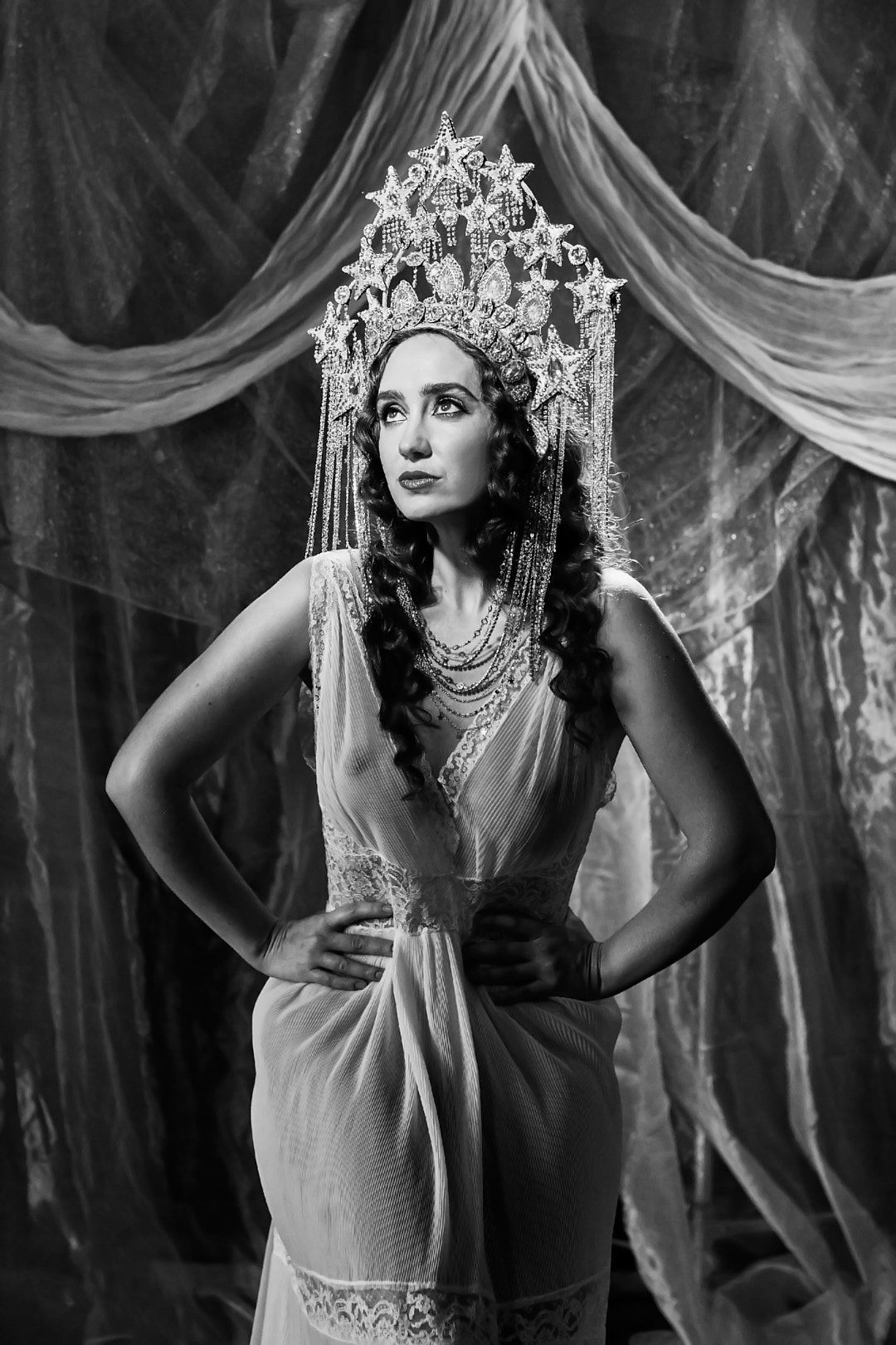 Dramatic black and white portrait featuring an ornate crown and vintage-style dress.