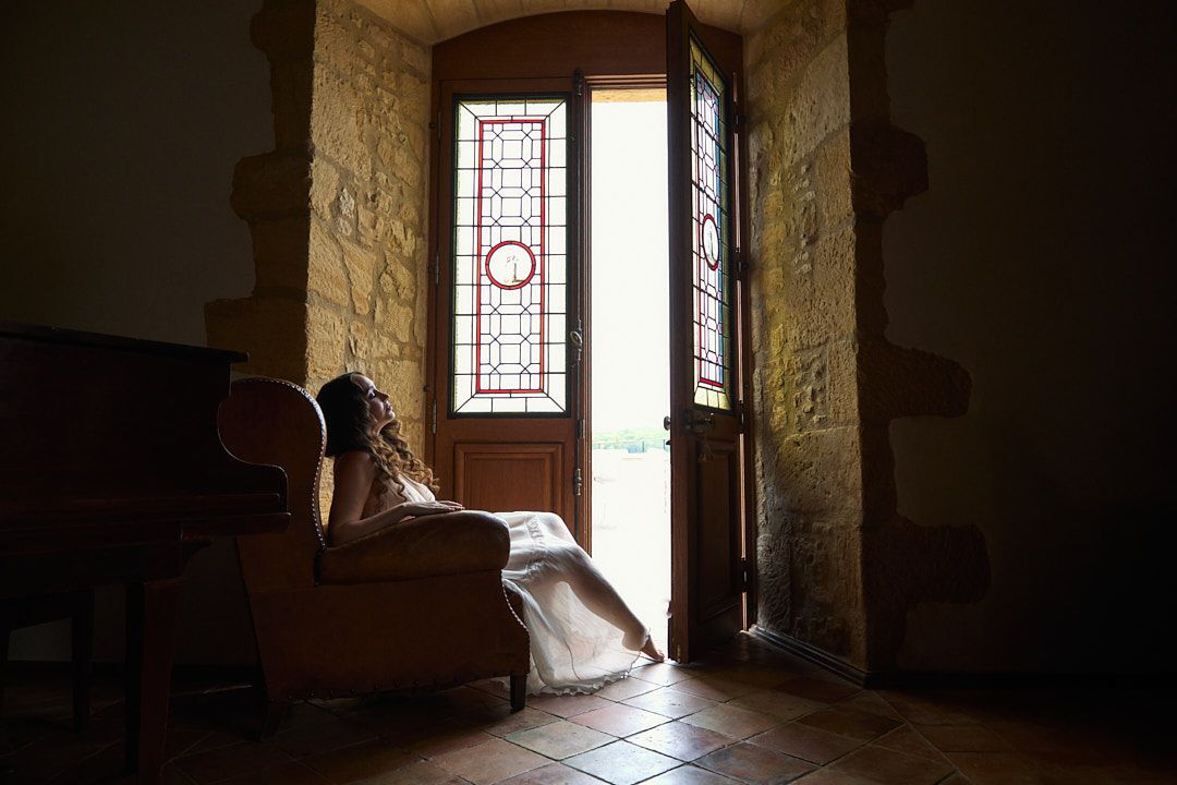 Stone room interior with dramatic lighting streaming through stained glass windows.