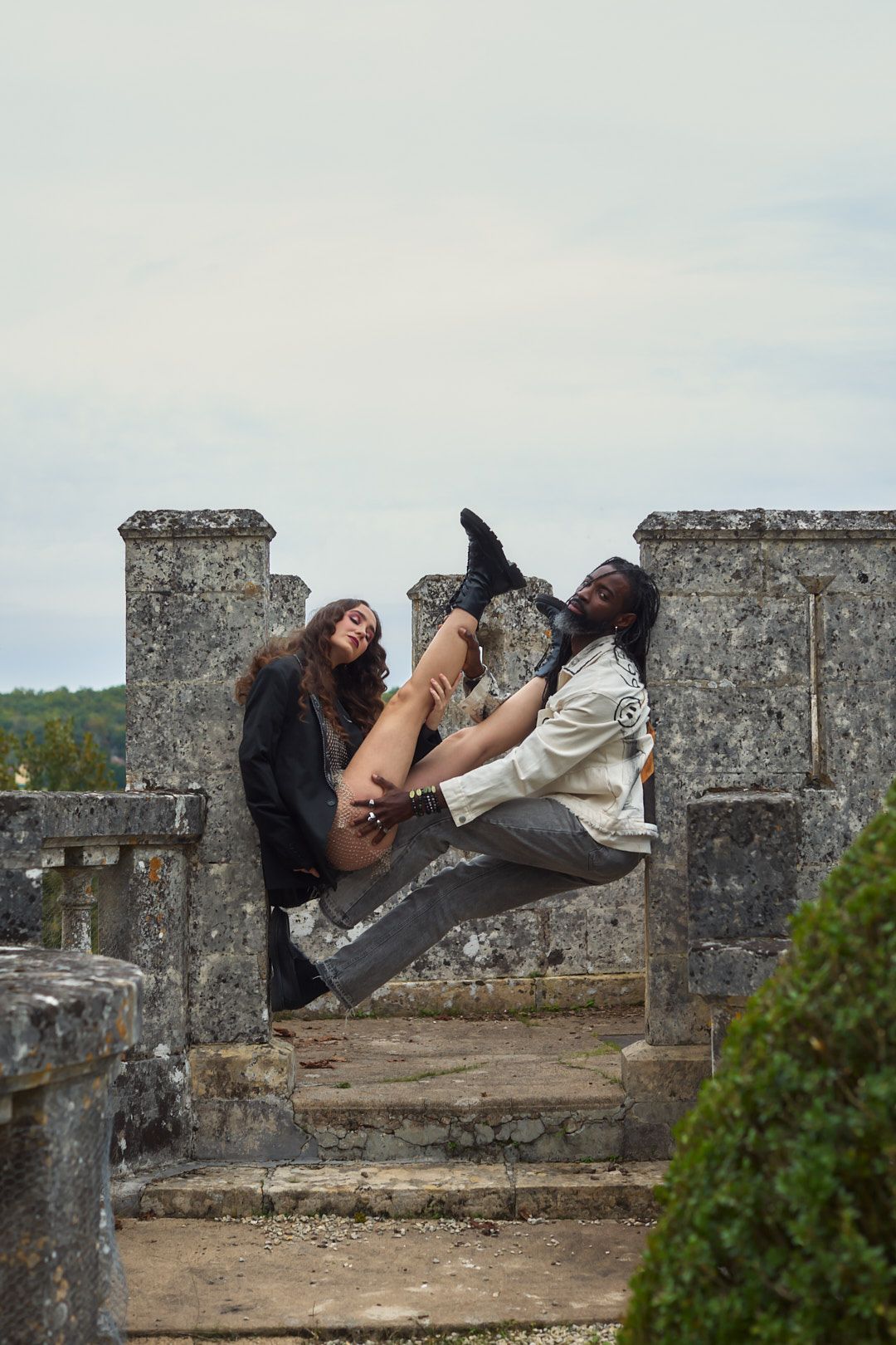 Creative portrait session on stone castle steps with dramatic poses.
