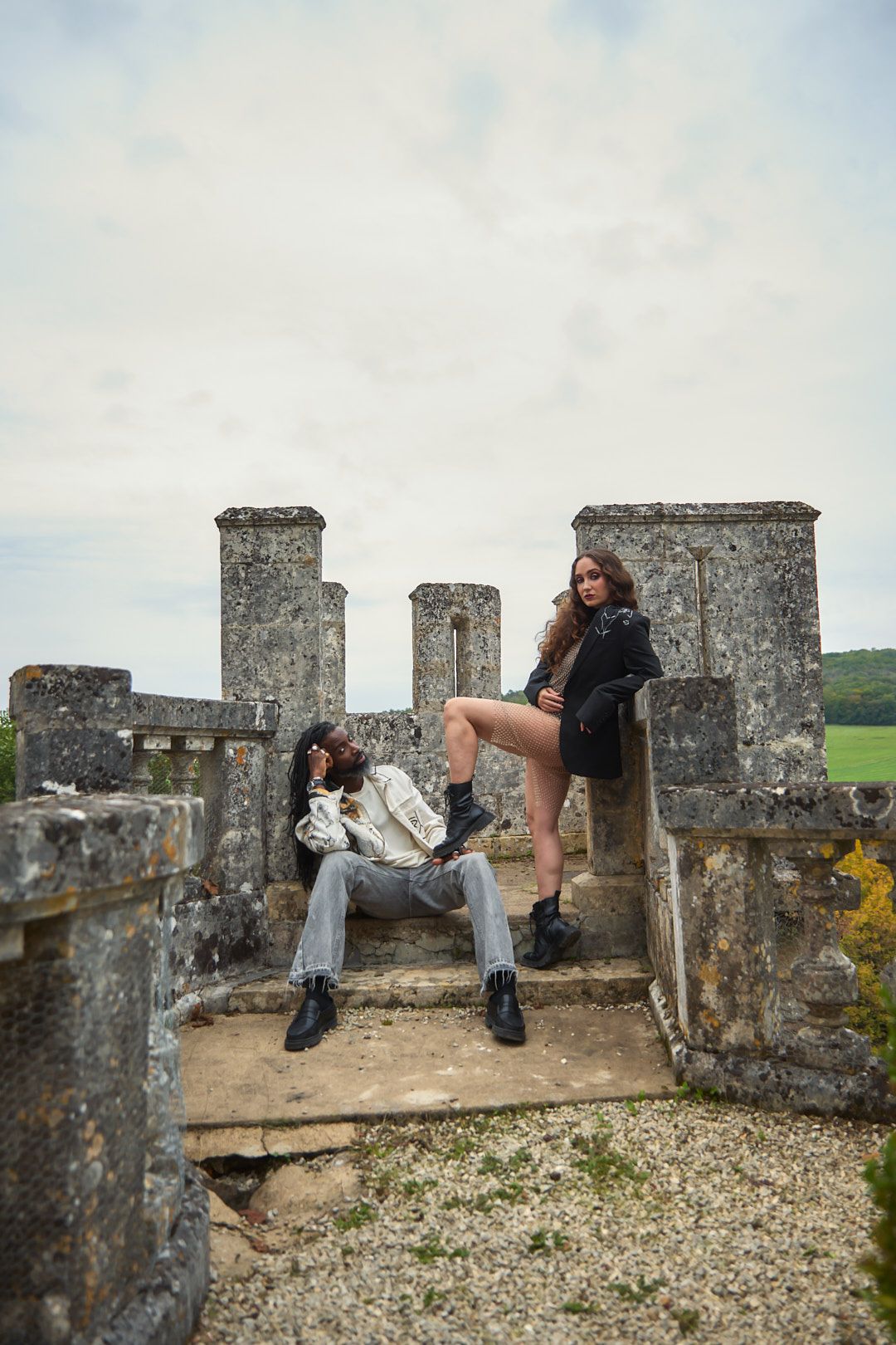 Artistic photoshoot on ancient stone castle walls with dramatic poses and natural lighting.
