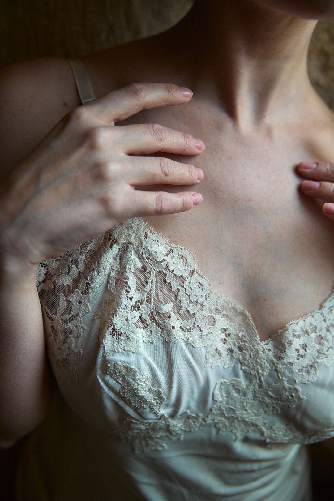 Intimate boudoir photo showing details of white lace lingerie.
