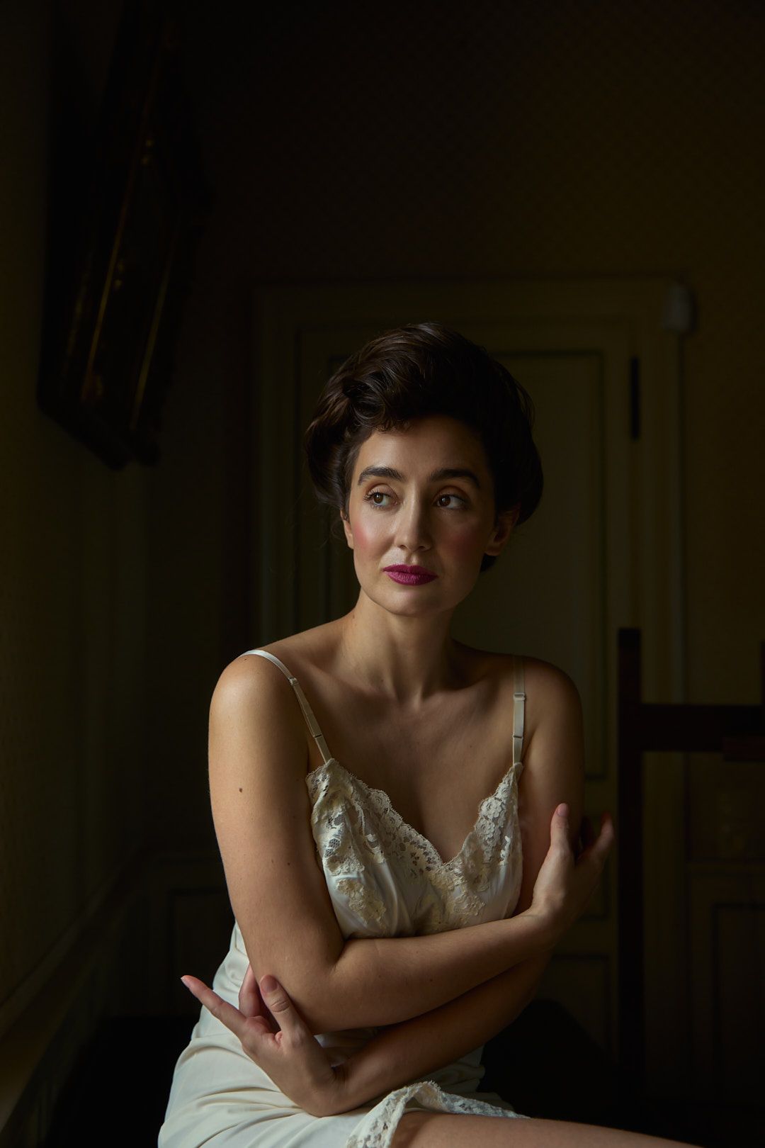 Dramatic portrait series with soft lighting showing a person in white dress against dark background.