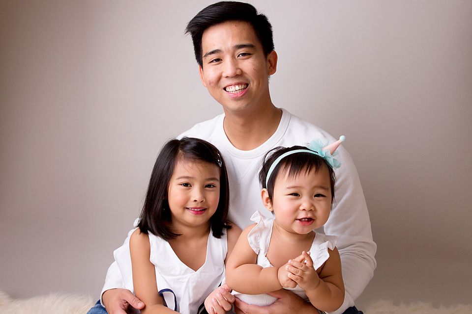 Casual family photo session with everyone wearing coordinated white outfits.