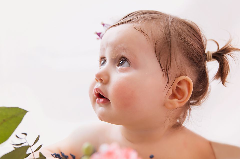 Close up portrait with tiny crown accessory against white background.