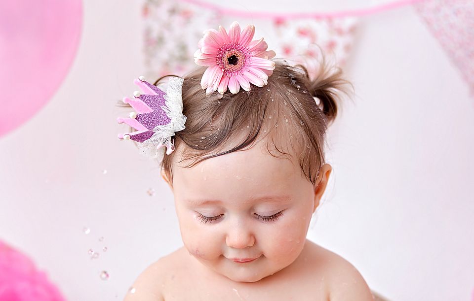 Birthday setup with pink gerbera flower and crown hair accessories.