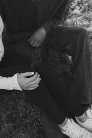 An intimate black and white photo of hands clasped together during a special moment.