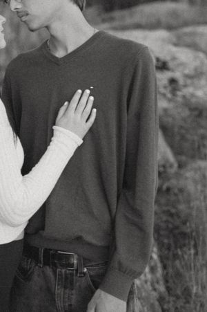 Close-up of a couple in black and white clothing against a natural backdrop.