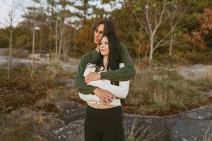 Intimate moment captured between a couple in an outdoor autumn setting.
