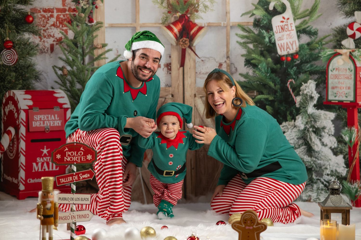 Family in matching holiday pajamas sits together on floor near Christmas tree during festive photo session.