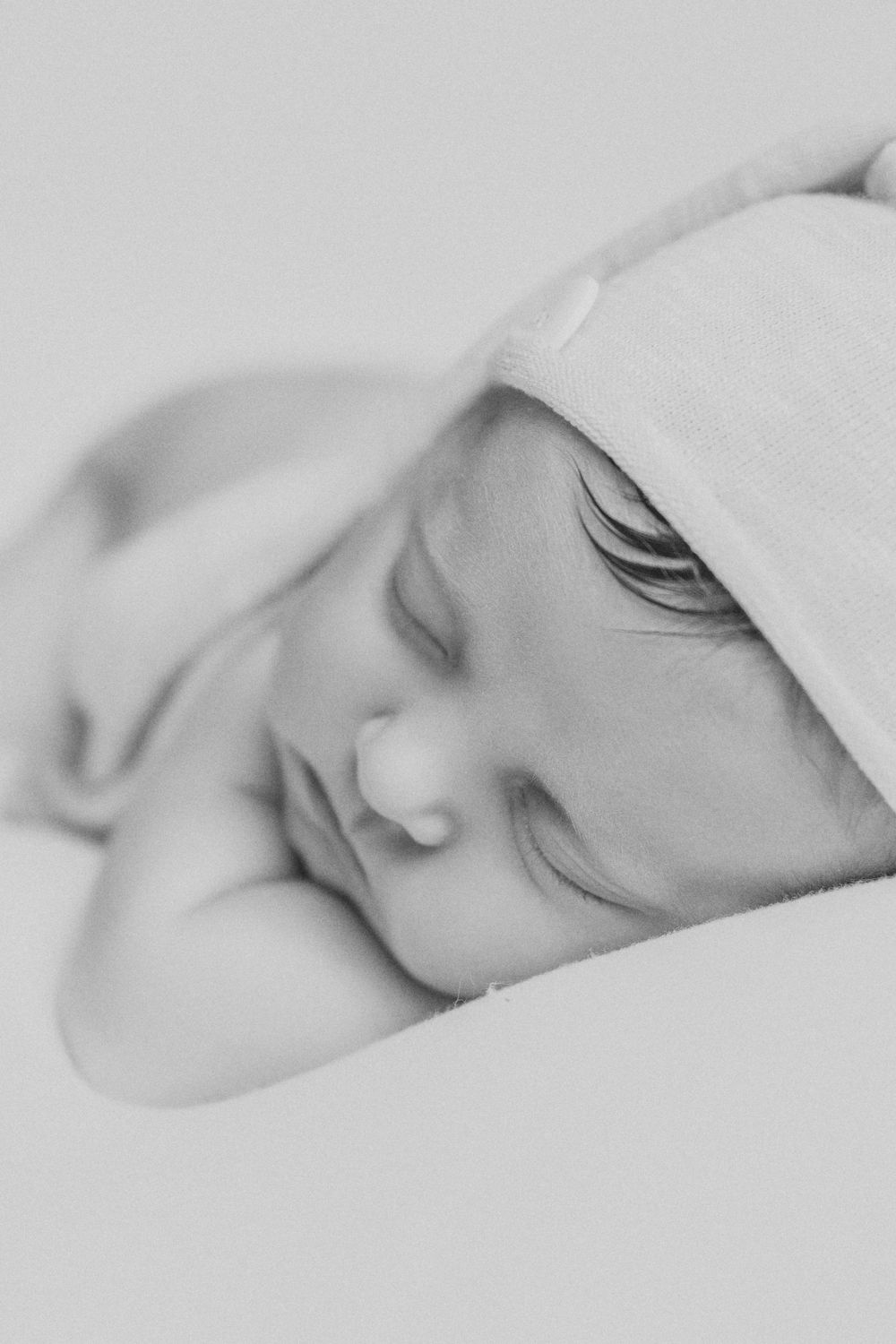 A series of black and white close-up photos showing a sleeping baby's face from different angles.