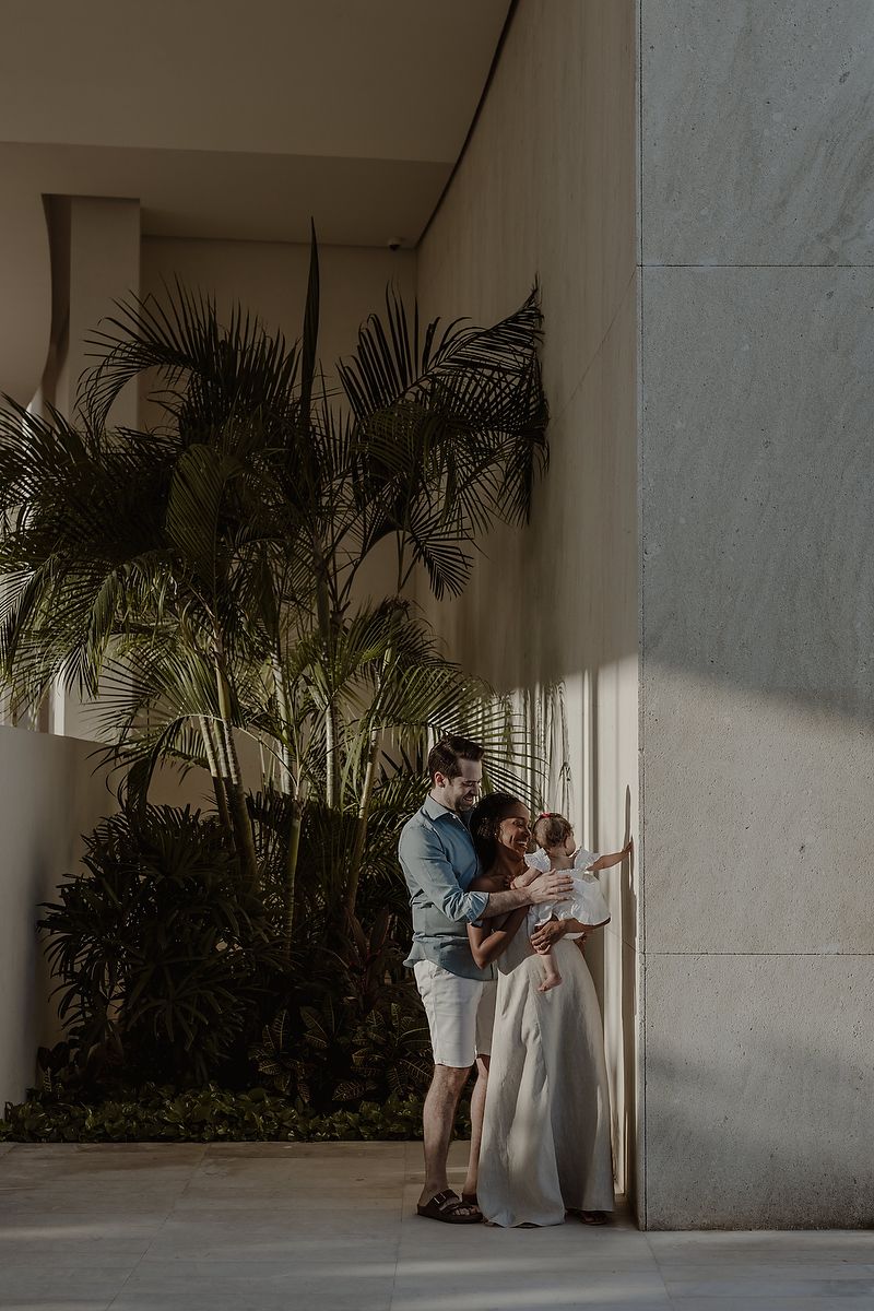 Family portrait at The St. Regis Kanai Resort, parents holding daughter during Riviera Maya vacation photoshoot.