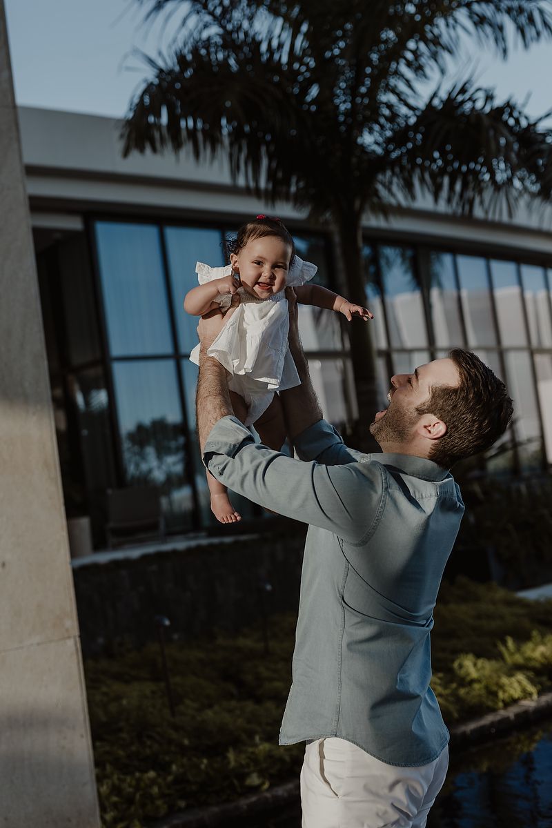 Father lifting daughter playfully in the gardens of The St. Regis Kanai Resort, Playa del Carmen family photos.