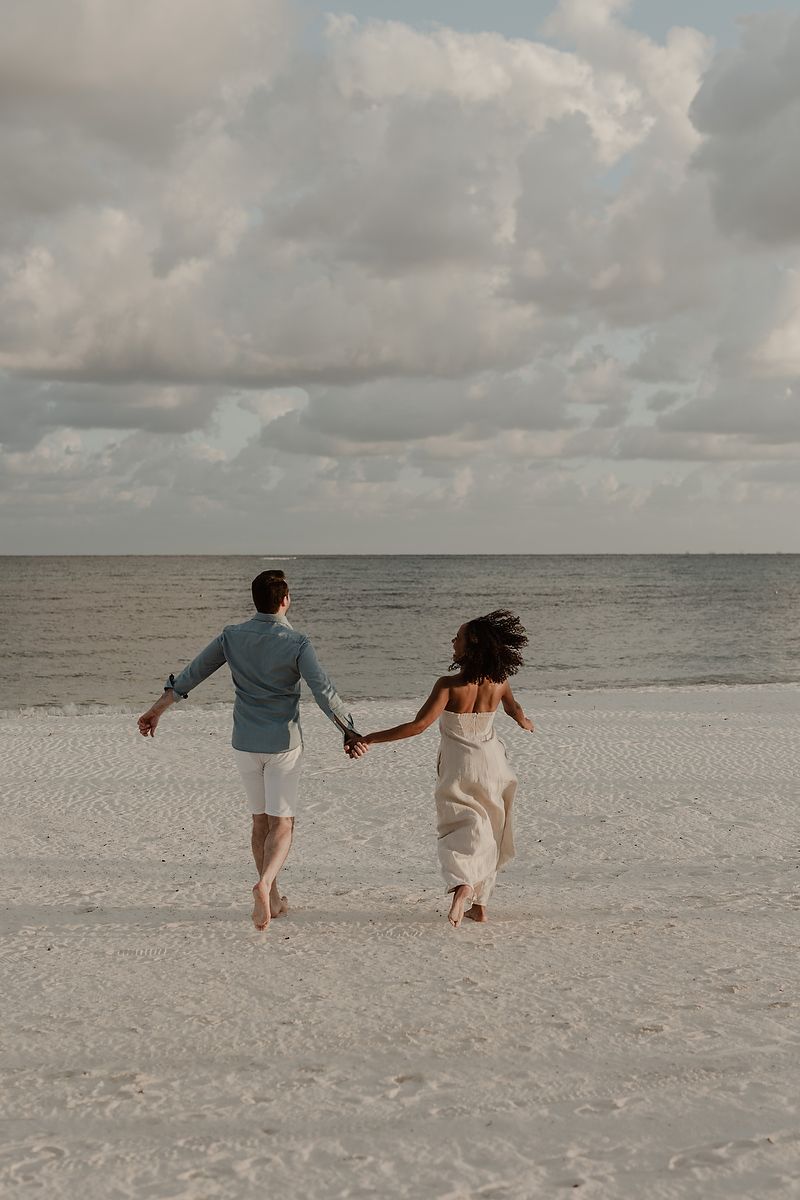 Parents walking hand in hand by the ocean in Playa del Carmen, Riviera Maya family photography.