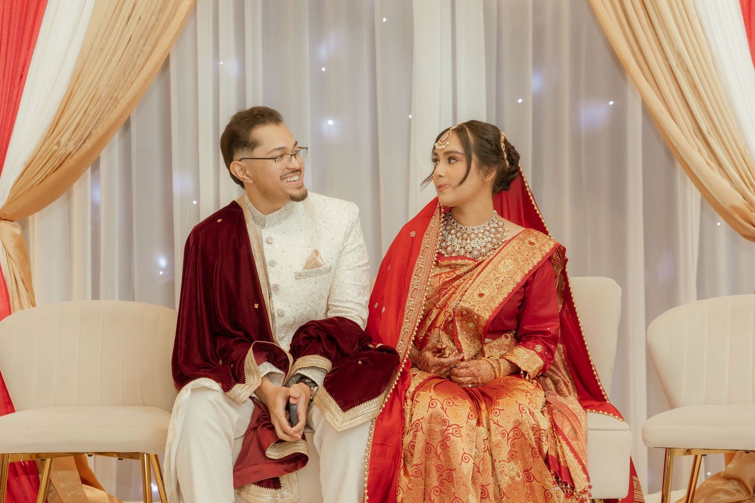 Bride and groom sharing a joyful moment on their wedding day, surrounded by elegant decor and loved ones.